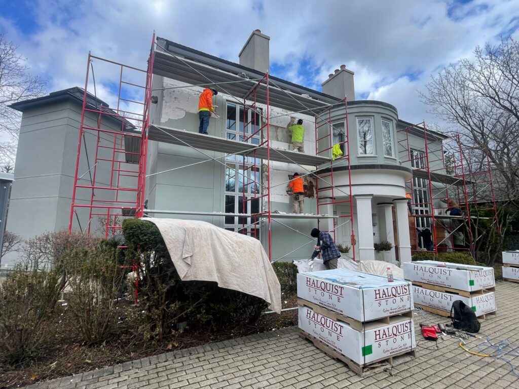 Original EIFS front elevation being stripped from the house